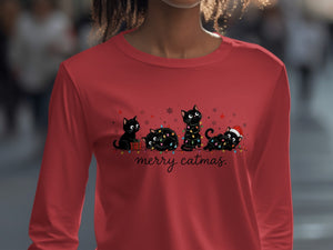 A red long-sleeve shirt with an illustration of four black cats tangled in Christmas lights and the text "merry catmas."
