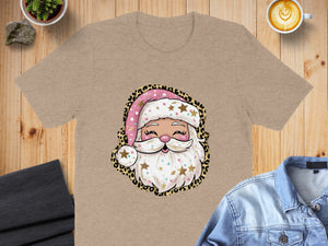 Tan t-shirt with sublimation print of a cute Santa Claus face with leopard print trim.
