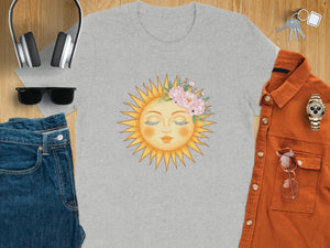 Grey t-shirt with a sun face adorned with pink flowers and green leaves.