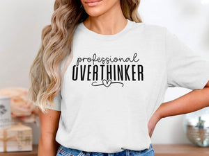 White t-shirt with black text "professional OVERTHINKER" and a heart.