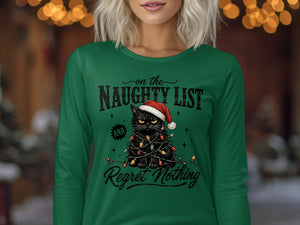 A woman wearing a green long-sleeved shirt with a black cat wearing a Santa hat wrapped in Christmas lights and the text on the Naughty List and Regret Nothing.