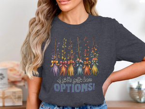 Dark t-shirt with a graphic of five decorative brooms and the text "A girl's gotta have OPTIONS!"