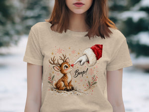 T-shirt with a drawing of a deer being booped by Santa's finger.