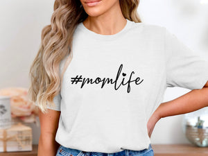 White t-shirt with black text "#momlife" and a small heart.