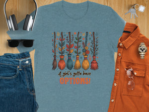 Teal t-shirt with cartoon brooms and text "A girl's gotta have OPTIONS!".