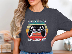 Shirt with graphic "Level 11 Unlocked" and a retro video game controller.