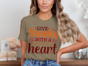 "Give thanks with a grateful heart" text on a taupe t-shirt with fall leaf accents.