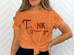 Orange t-shirt with "Happy Thanks Giving" text design tied at waist.