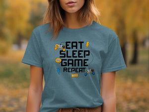 Blue t-shirt with text "Eat Sleep Game Repeat" and video game controllers.