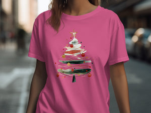 Pink t-shirt with a watercolor-style Christmas tree and ornaments graphic.