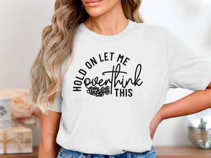 White t-shirt with black text reading "HOLD ON LET ME overthink THIS"