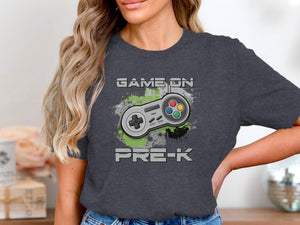 Dark t-shirt graphic with "GAME ON PRE-K" text and a retro video game controller.