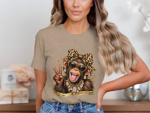 T-shirt graphic of a monkey wearing sunglasses, bandana, and jewelry, making a peace sign.