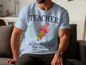 Light blue t-shirt with "TEACHER Social Club TEACH LOVE INSPIRE" text and pencil design.