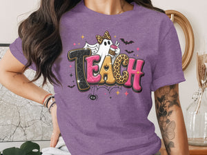 Purple t-shirt with "TEACH" text, ghost, coffee cup, bats, and spider.