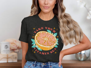 Dark t-shirt graphic with grapefruit, leaves, flowers, and text "TAKE YOUR VITAMIN SEA".