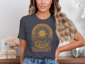 Radiate positivity graphic on a dark grey t-shirt with sun, rainbow, flowers, and cacti.