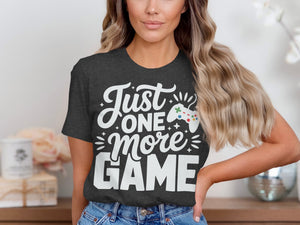 Dark gray t-shirt with white text "Just one more GAME" and a video game controller.