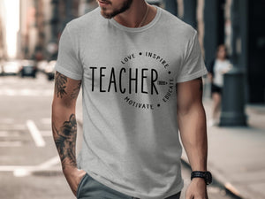 Grey t-shirt with black text "TEACHER" and circular design elements.