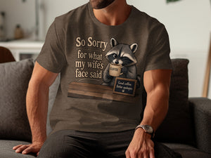 T-shirt graphic with raccoon holding coffee and text "So Sorry for what my wife's face said".