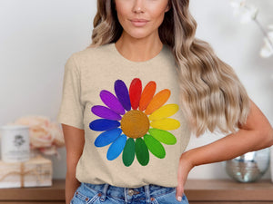 Beige t-shirt featuring a multi-colored painted daisy graphic with a golden center.