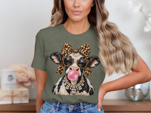 Cow with leopard bow, sunglasses, and jeweled necklace blowing pink bubble gum.