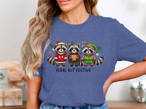 Three raccoons in Christmas attire with text "FERAL BUT FESTIVE".