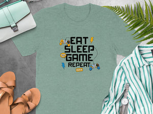 Green t-shirt with "Eat Sleep Game Repeat" and game controller graphic.