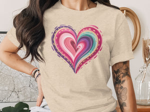 Beige t-shirt with a colorful, swirled heart graphic and gold accents.