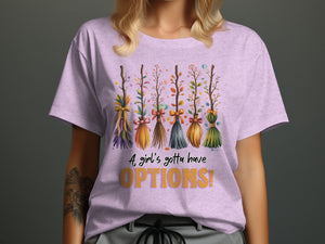 Lavender t-shirt with whimsical brooms and text "A girl's gotta have OPTIONS!"