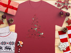 Red t-shirt with abstract watercolor Christmas tree design surrounded by festive decor.