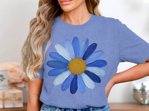 Blue t-shirt with a textured blue daisy graphic and gold center.