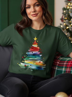 Green t-shirt with a watercolor Christmas tree graphic featuring colorful brushstrokes.