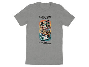 Grey t-shirt with stacked video game controllers and text "LET'S PLAY NOW!" and "NEVER SAY GAME OVER!".