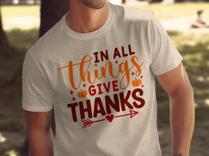 Light gray t-shirt with "In All Things Give Thanks" text and pumpkin graphics.