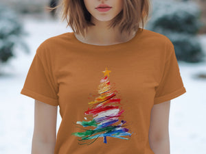 Orange t-shirt with a rainbow watercolor Christmas tree graphic.
