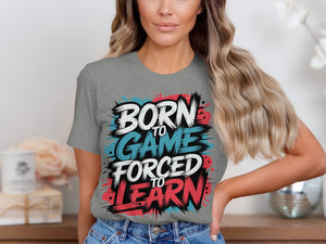 Gray t-shirt with text "BORN TO GAME FORCED TO LEARN" in colorful distressed font.