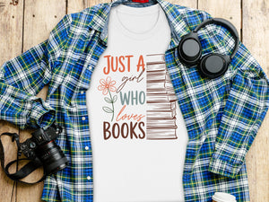 White t-shirt with "Just a girl who loves books" graphic and stack of books.