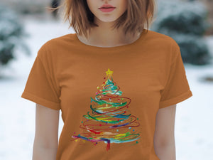 Orange t-shirt with abstract Christmas tree graphic featuring colorful brushstrokes.
