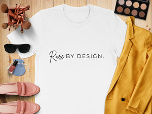 White t-shirt with "Rare BY DESIGN." text, makeup brushes, sunglasses, and shoes.