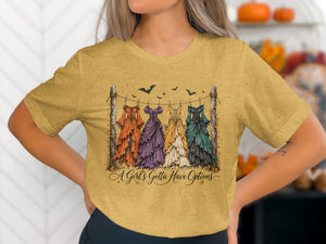 T-shirt graphic: four vintage dresses on a clothesline with bats and text "A Girl's Gotta Have Options."