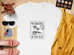 White t-shirt with a black stamp design that says "Waikiki Honolulu Est 1907 Hawaii".