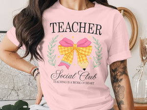 Pink t-shirt with "Teacher Social Club Teaching is a Work of Heart" graphic.