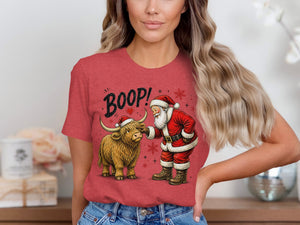 Santa boops a Highland cow with "BOOP!" text on a red t-shirt.