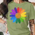 Green t-shirt with a colorful painted daisy design featuring rainbow petals and a gold center.