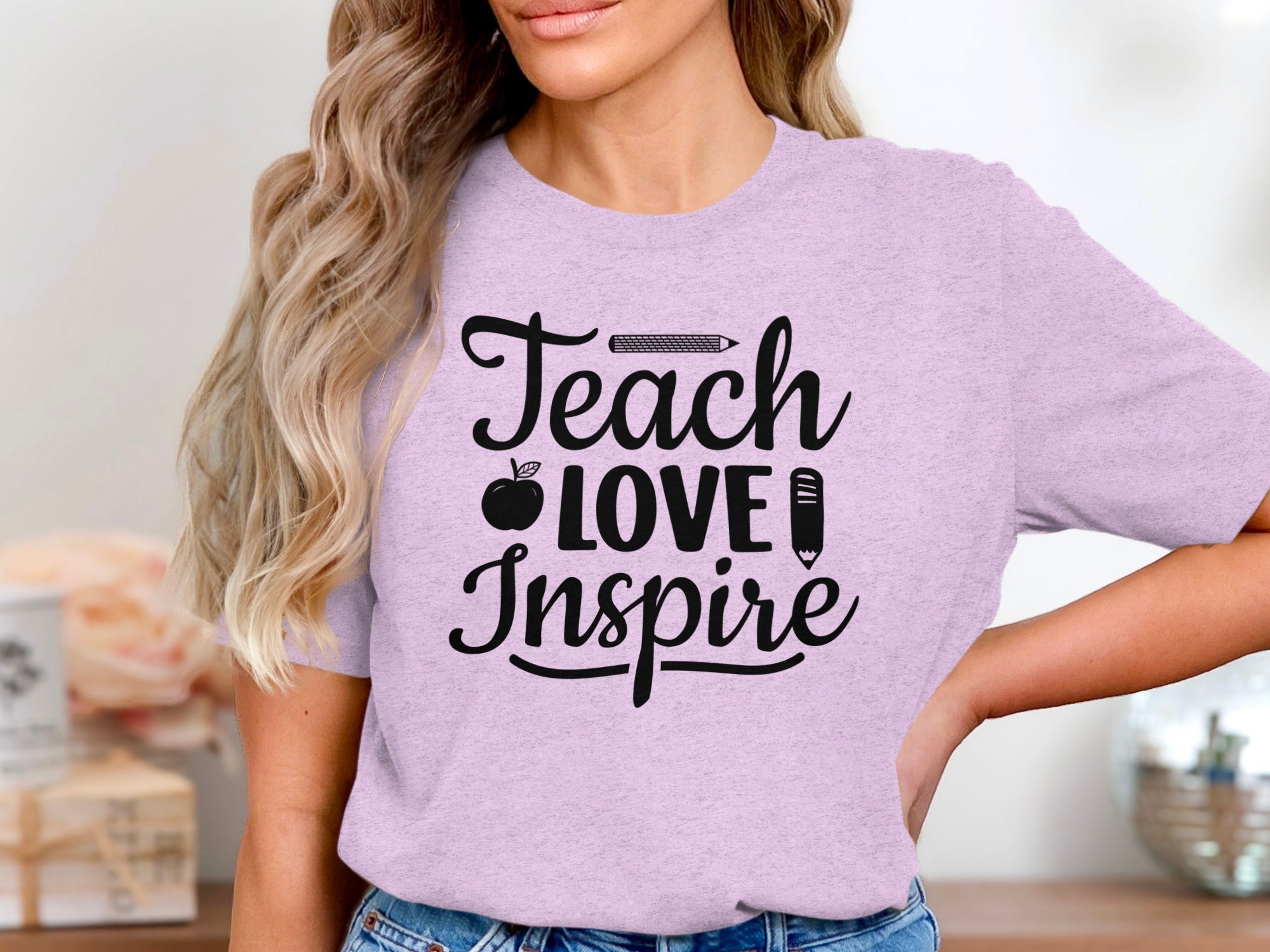 Purple t-shirt with "Teach Love Inspire" text and apple and pencil graphics.