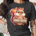 Cartoon squirrel with "FOOD LOVER" text on a wooden sign on a dark t-shirt.