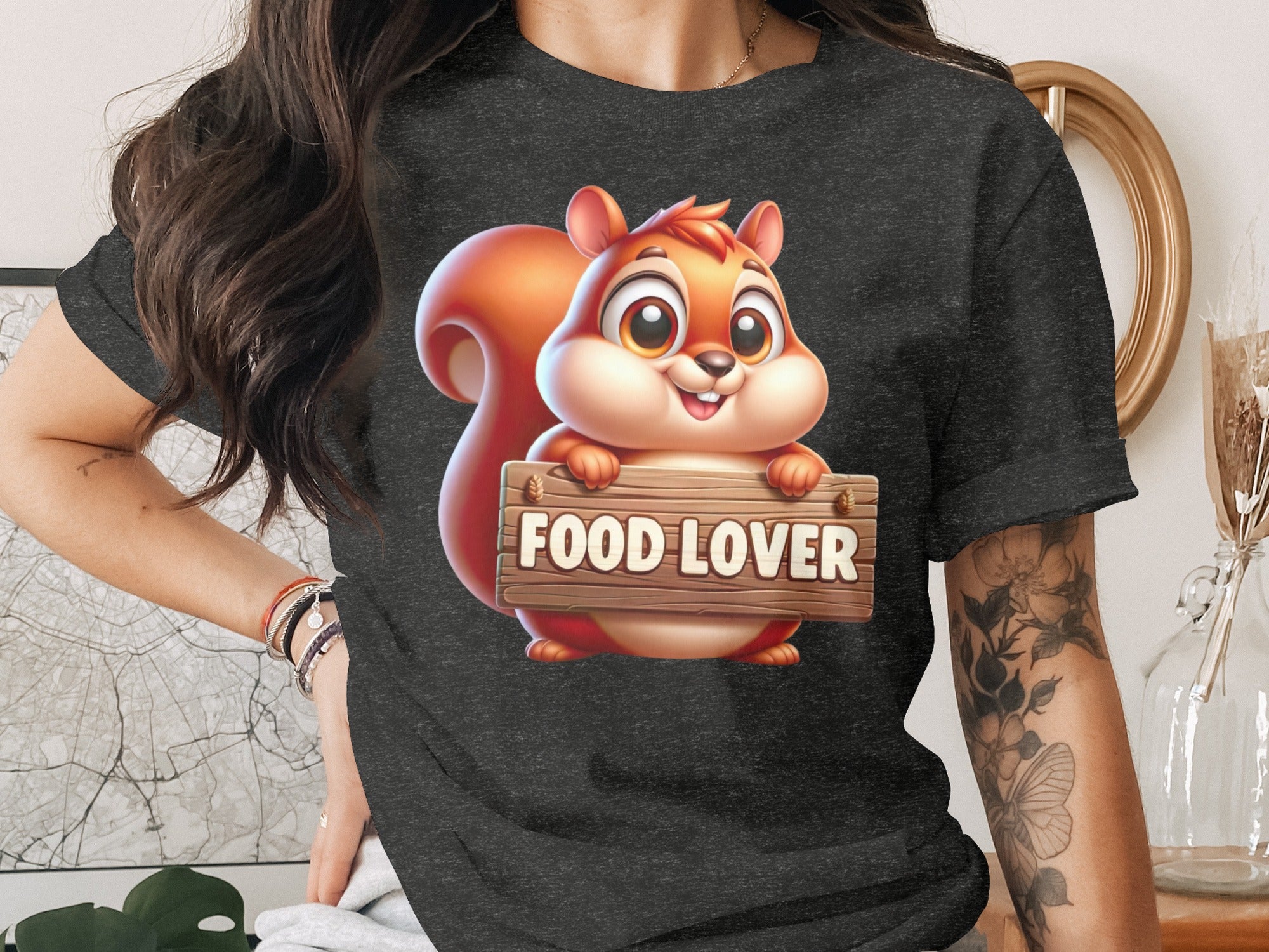 Cartoon squirrel with "FOOD LOVER" text on a wooden sign on a dark t-shirt.