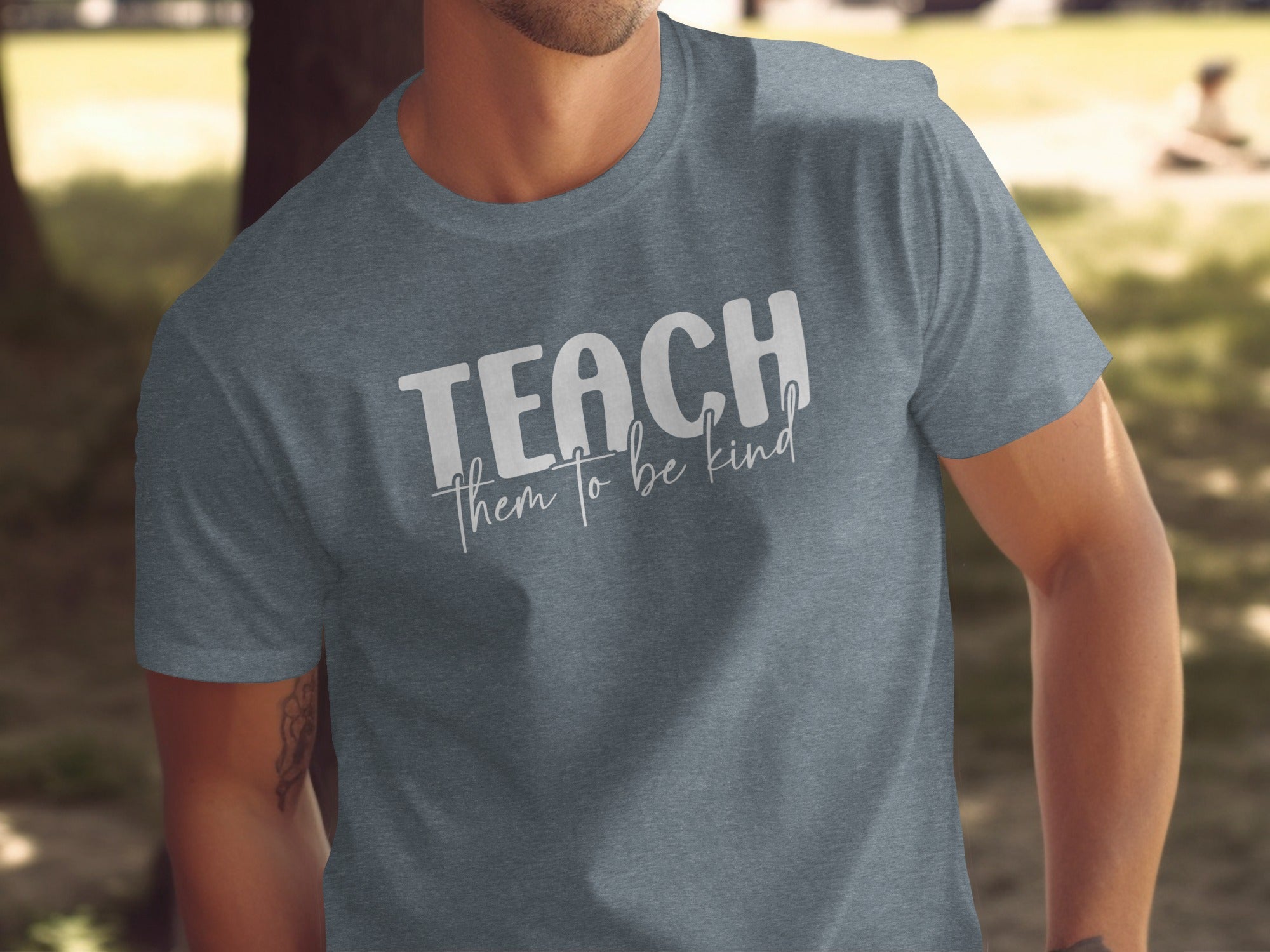 Charcoal t-shirt with "TEACH them to be kind" white text.