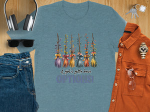 Blue t-shirt with witch broom graphic saying "A girl's gotta have OPTIONS!".